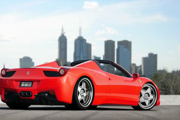 Ferrari rojo tuneado en el fondo de la ciudad