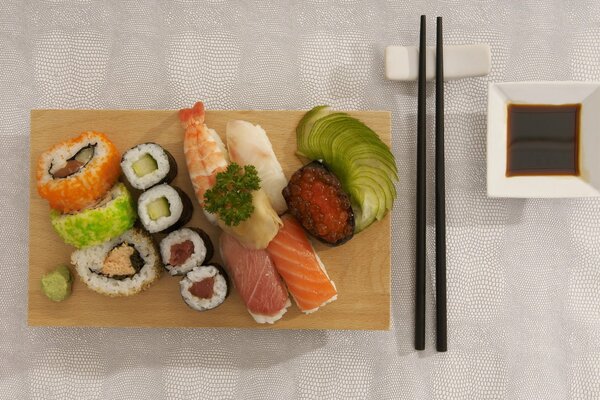 Sushi et petits pains sur un plateau avec des baguettes et de la sauce