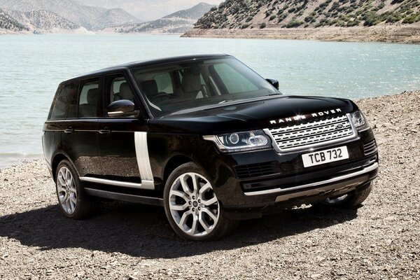 The land Rover car stands in front of the lake