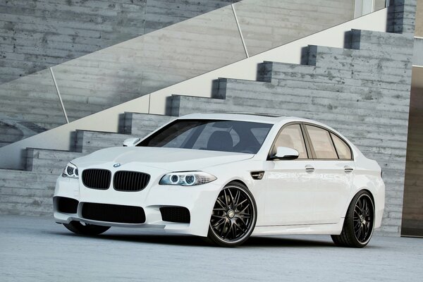 White BMW with black wheels near the picturesque staircase