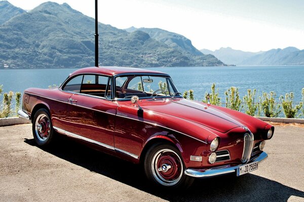 Red bmw 1956 on the background of mountains and river
