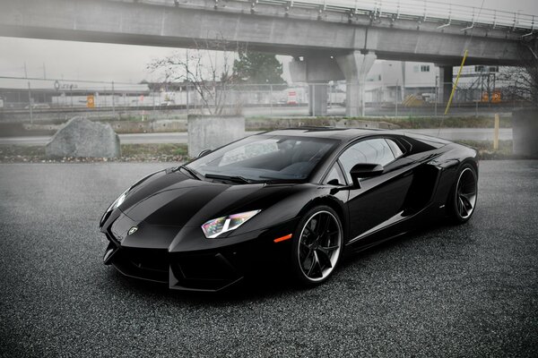 Abandoned black lambo in an abandoned parking lot 