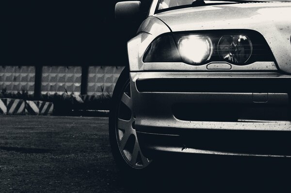 The headlight of a silver bmw car