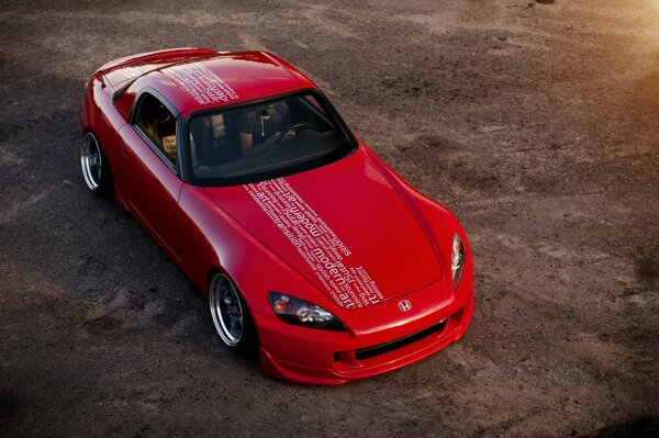 Red sports car with inscriptions on the roof and hood