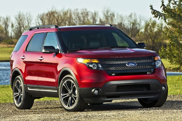 Red SUV in nature by the pond