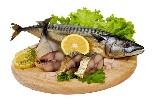 Mackerel on a cutting board with lemon and herbs