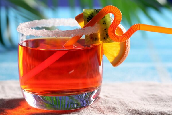 Cocktail with kiwi straw and orange