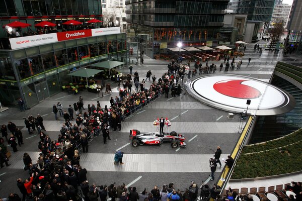 Une voiture de formule 1 entourée de fans de course automobile