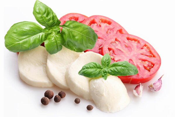 Tranches de fromage tomate et feuilles de basilic