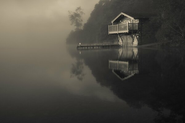 See im Nebel mit einsamem Haus