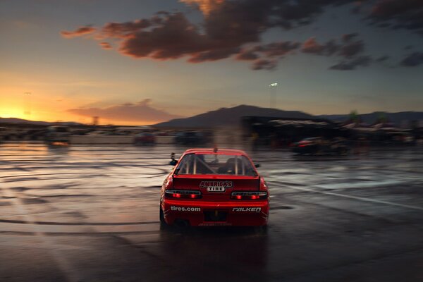 Coche deportivo rojo a la luz de la puesta de sol carmesí