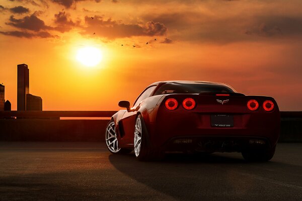 Car on the embankment during sunset in the city