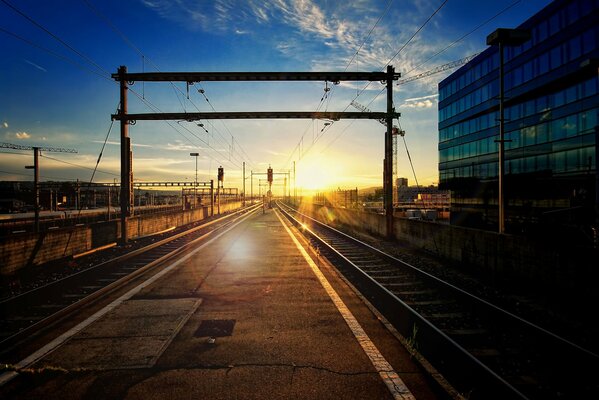 Tramonto alla stazione ferroviaria con la ferrovia