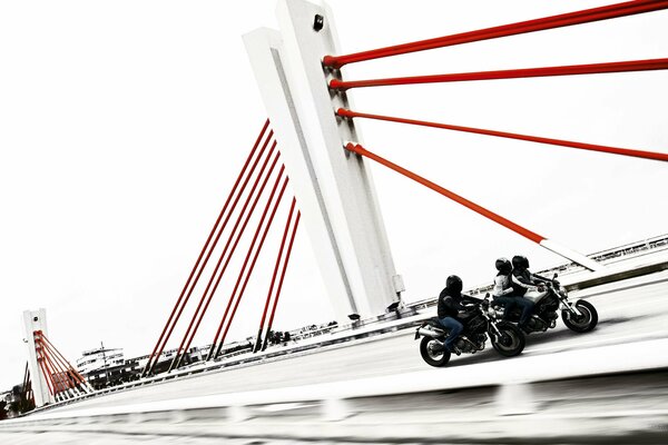 Motociclistas circulan por puente blanco