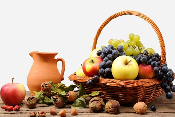 Fruits and nuts in a wicker basket with a jug