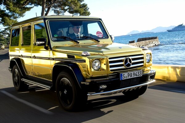 La jeep d oro Mercedes guida lungo la costa