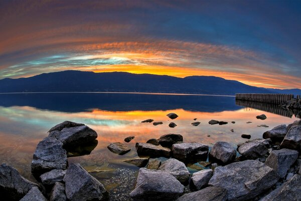 Puesta de sol por la noche en el lago con piedras