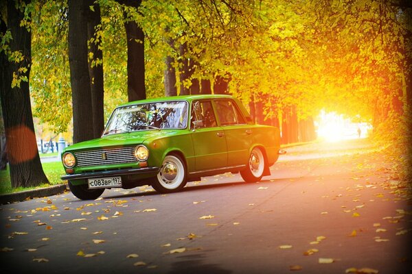 Grünes Auto Lada auf dem Hintergrund der Herbststraße