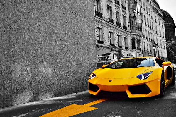 Yellow Lamborghini on the road in a black and white city