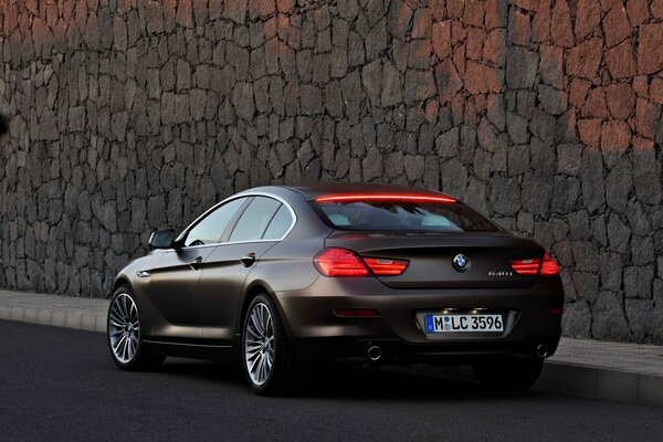 Bmw 2013 against a stone wall