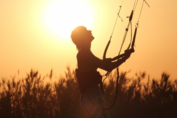 Chico con paracaídas al atardecer