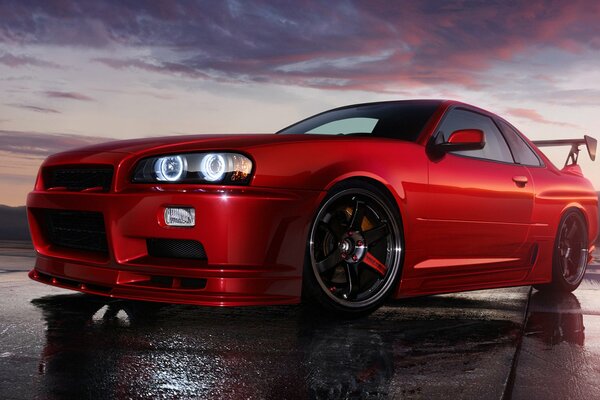 Hermoso coche deportivo rojo bajo el cielo