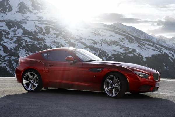 Coche rojo con capucha larga en las montañas