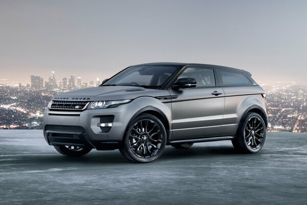 Silver range Rover on the background of the panorama of the city