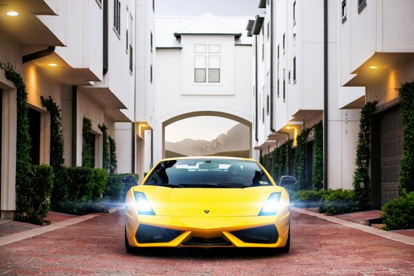 Yellow Lamborghini on the cobblestones in the yard at the house