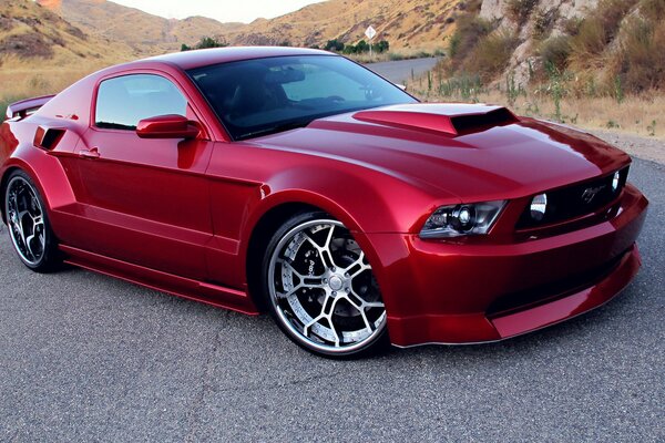 Red tuned ford mustang with alloy wheels