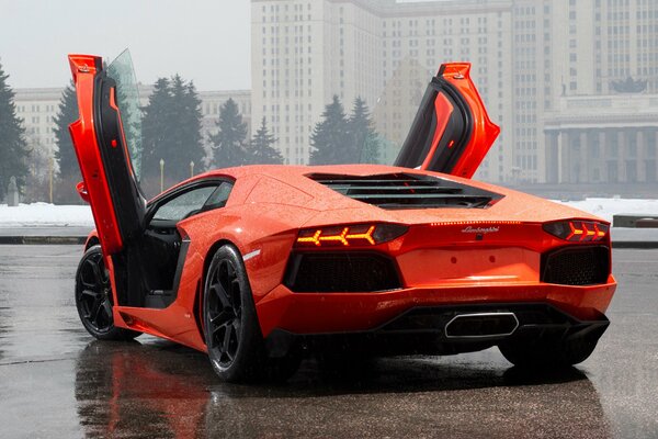 Pomarańczowy Lamborghini Aventador LP700-4, widok z tyłu z otwartymi drzwiami skrzydłowymi