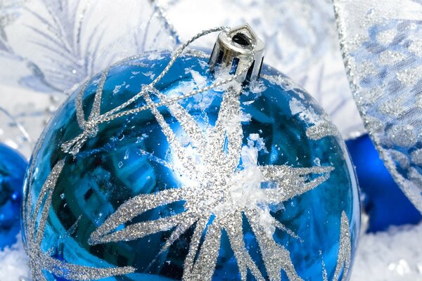 Blaue Christbaumkugel mit glänzender Schneeflocke