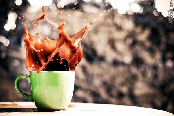 Salpicaduras, salpicaduras de café en una taza verde