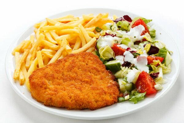 Almuerzo en un plato-chuleta, papas fritas y ensalada