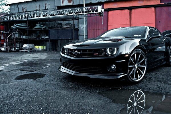 Voiture de sport noir sur fond de garages et pneus