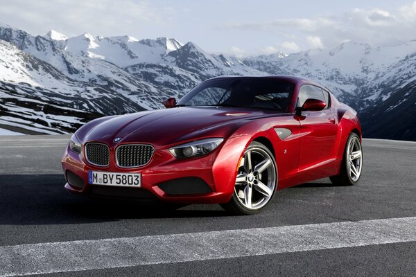 Ein roter Bmw steht im Hintergrund der Berge