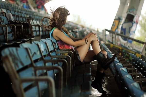 Thoughtful girl sitting at the stadium