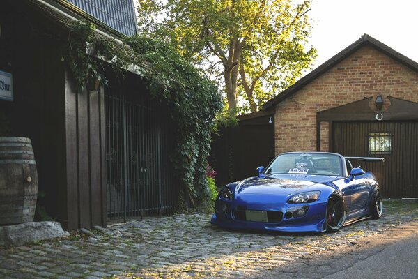 Vue de face sur une Honda S2000 bleu sur fond de maison