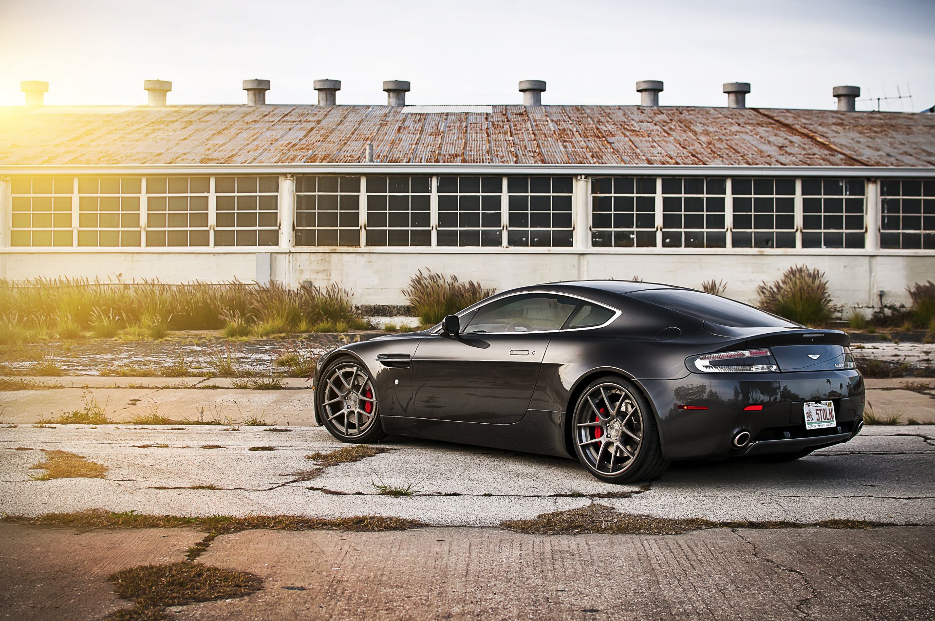 aston martin v8 vantage schwarz aston martin rückseite hangar sonne blendung