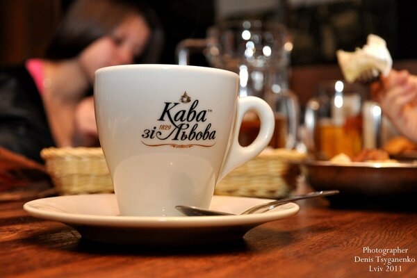 Kaffeetasse mit Löffel auf Bier Hintergrund