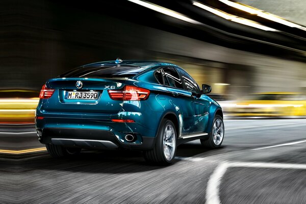 Une bmw X6 bleue cool se précipite sur la route