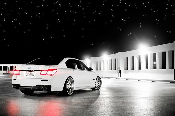 Hay un coche blanco y alrededor de un hermoso cielo estrellado