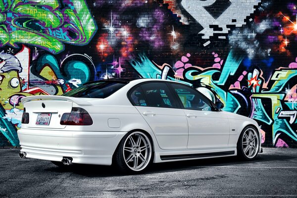 Tuned BMW 3 series on the background of graffiti