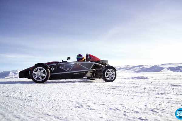 Supersportwagen in der verschneiten Wüste mit einem Mann im Helm