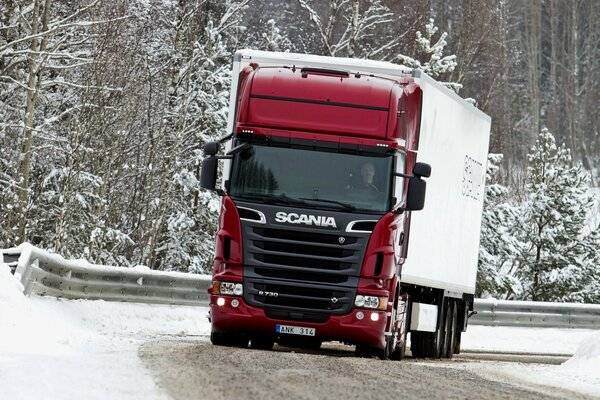 Roter Scania-LKW auf verschneiter Strecke