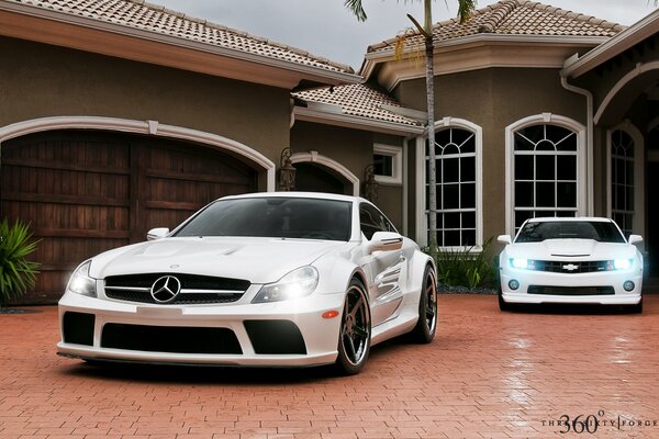 Mercedes y Chevrolet blancos en el fondo de la casa