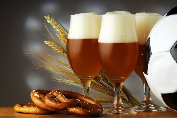 Una naturaleza muerta con temática de fútbol con cerveza, pretzels salados y una pelota en blanco y negro