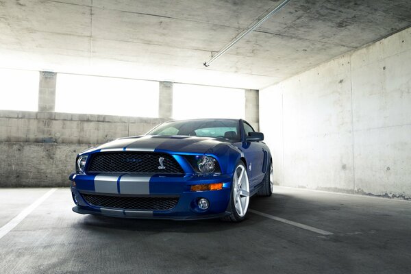 Blauer Ford Mustang fährt schnell durch die Stadt