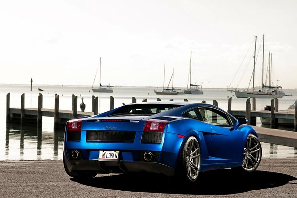 A blue Lamborghini gallardo stands on the dock