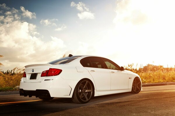 A white car on the road in the sunset